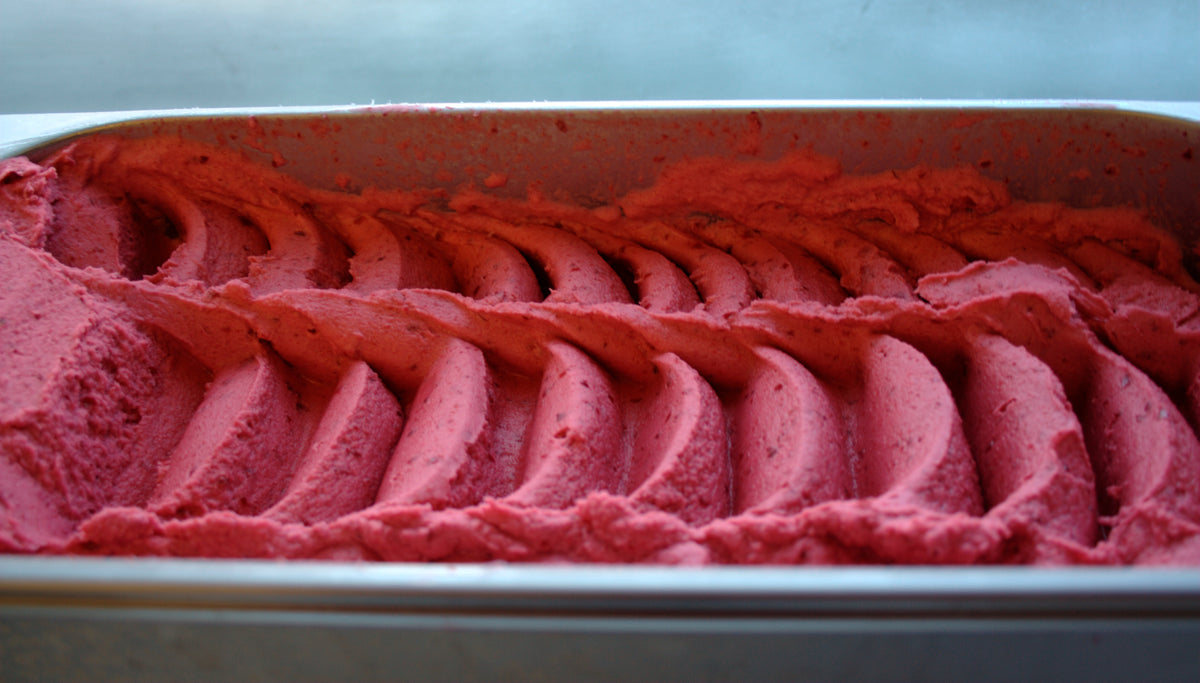 Raspberry sorbetto in a container with a wavy pattern