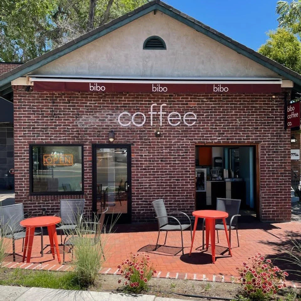 Brick building with 'bibo coffee' sign and outdoor seating area.