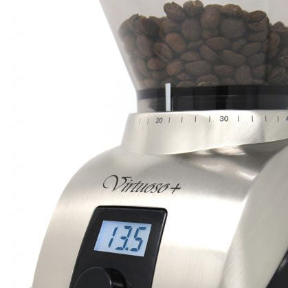 Coffee grinder with coffee beans and digital display on a white background